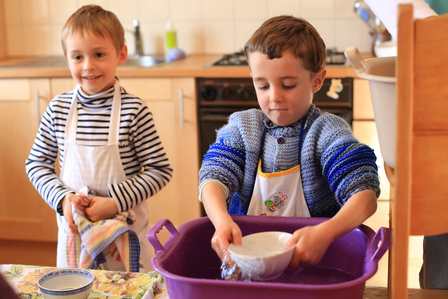 Petits enfants faisant la vaisselle à l'école Steiner Waldorf